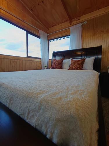 a bedroom with a large bed with a large window at El Al Patagonia in Puerto Natales