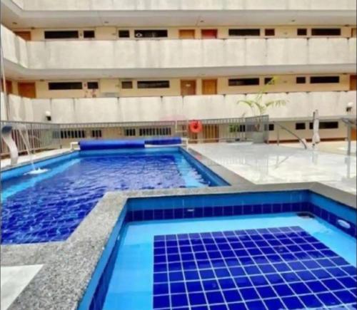 a swimming pool with blue tiles in a building at Kit 102 Brasília in Brasilia