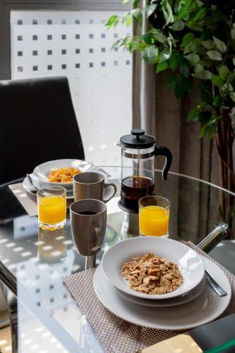a table with two plates of food and orange juice at Belfry Quarters, Redhill in Redhill