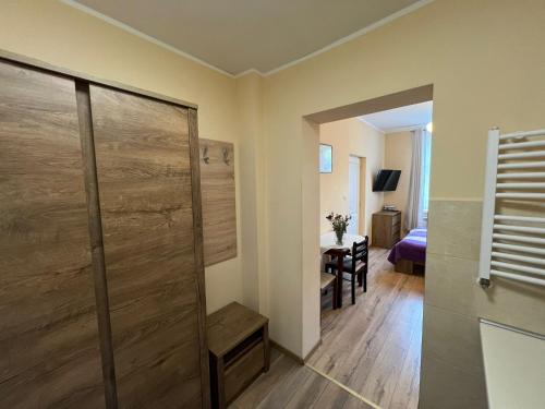a bathroom with a shower and a room with a table at Willa Zofia in Krynica Zdrój