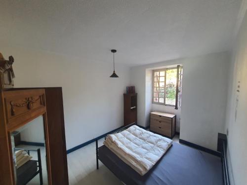 une chambre avec un lit et une fenêtre dans l'établissement La maison dô, à Frayssinet-le-Gélat