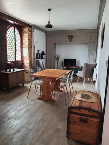 un salon avec une table et des chaises en bois dans l'établissement La maison dô, à Frayssinet-le-Gélat