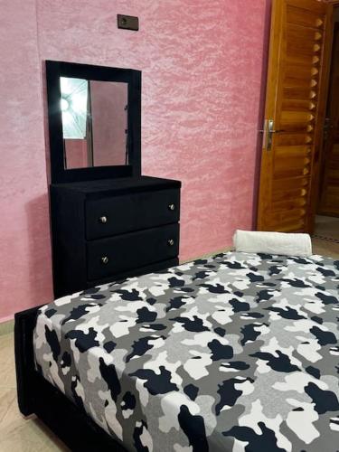 a bedroom with a bed and a dresser and a mirror at Appartement fes centre in Fès