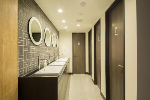 a bathroom with two sinks and a mirror at Emblem Hostel Nishiarai in Tokyo