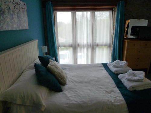 a bedroom with a bed with towels on it at The Liscawn in Torpoint