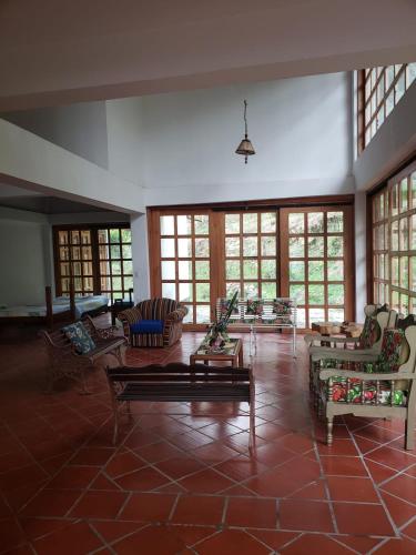 a large living room with couches and tables and windows at Hotel Campestre Villa Nico in Bochalema