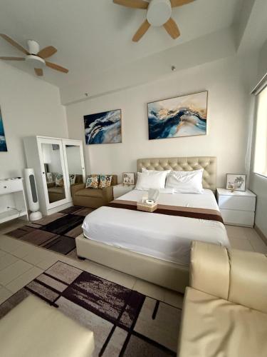 a bedroom with a large bed and a couch at JK Suites Cheer B126 in Marilao