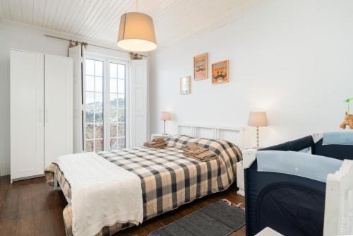 a bedroom with a bed and a couch and a window at Casa da Fraga in Santa Marta de Penaguião