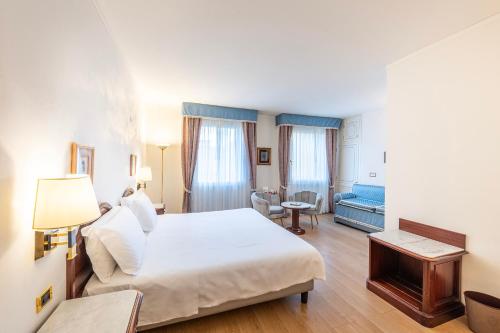 a hotel room with a large bed and a desk at Majestic Toscanelli (centro storico) in Padova