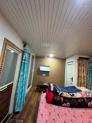a room with a bed and a tv on the ceiling at ANURAG HOMESTAY in Kurseong