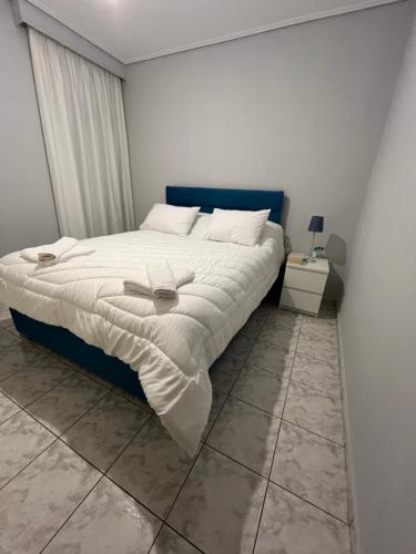 a bedroom with a bed with a blue headboard at Linda's Apartment in Tríkala