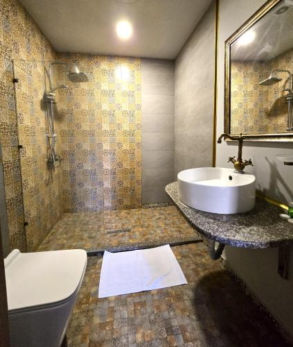 a bathroom with a sink and a shower and a toilet at Sahil İnn Hotel Formula 1 view in Baku