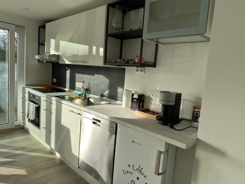 a kitchen with white cabinets and a sink at FerienWohnung Gästehaus Merzig-Besseringen NEUBAU in Merzig