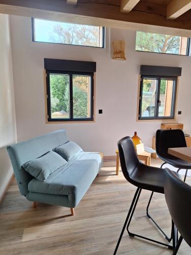 un salon avec un canapé et une table dans l'établissement Lodge les ombelles, à Coutras