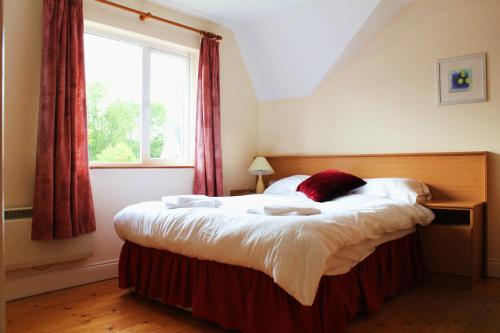 a bedroom with a large bed and a window at Kerry-Lee Holiday Homes Tralee in Tralee