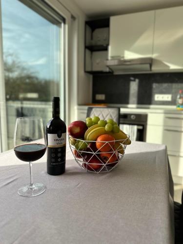 a glass of wine and a bowl of fruit on a table at FerienWohnung Gästehaus Merzig-Besseringen NEUBAU in Merzig