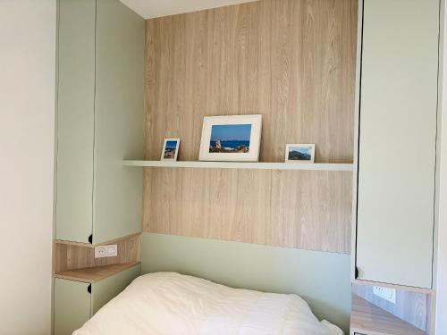 une chambre avec un lit et un mur en bois dans l'établissement appartement 2 chambres vue mer imprenable marine de Sant Ambrogio LUMIO, à Lumio