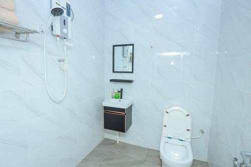 un bagno bianco con wc e doccia di D' Village Cottage 2 - Private Pool Villa a Pantai Cenang