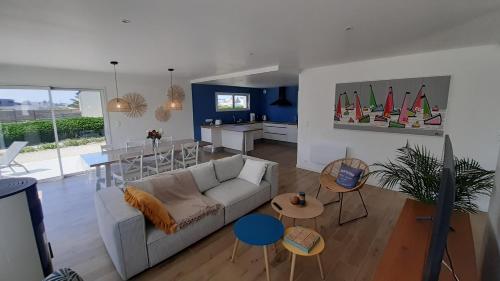 un salon avec un canapé et une salle à manger dans l'établissement Maison neuve à deux pas de la superbe plage des Amiets, à Cléder