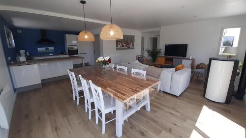 Il dispose d'une cuisine et d'un salon avec une table et des chaises en bois. dans l'établissement Maison neuve à deux pas de la superbe plage des Amiets, à Cléder
