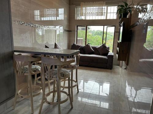 Nyathi's Guest House في هيبردين: مطبخ مع بار مع المقاعد وأريكة