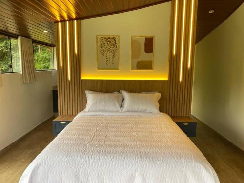 Giường trong phòng chung tại Loft Vidro Lake Rota do Vinho São Roque