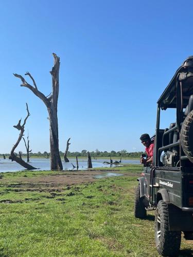 a person in a jeep parked next to a body of water at Nice View Safari villa in Udawalawe