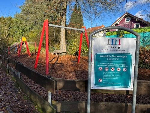 a sign in front of a park with swings at FerienWohnung Gästehaus Merzig-Besseringen NEUBAU in Merzig