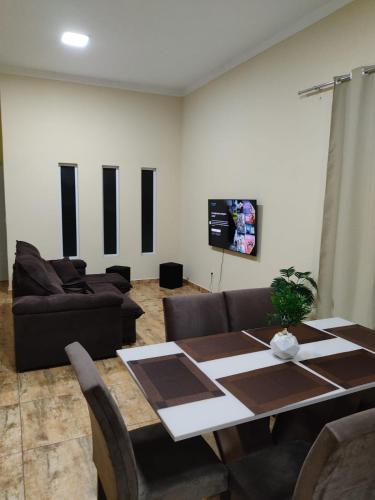 a living room with a table and a couch at Green Home in Águas de Santa Barbara