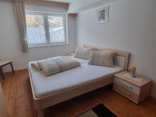 ein Bett in einem Zimmer mit Fenster in der Unterkunft Haus Aras in Prutz
