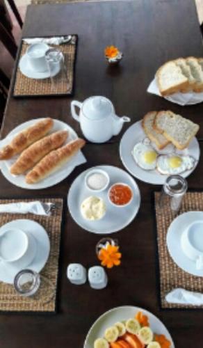 a table with plates of breakfast food on it at Bakery Family Guest House in Mirissa