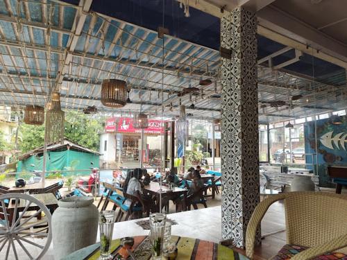a restaurant with tables and people sitting at tables at Amore Serenity Resort in Arambol