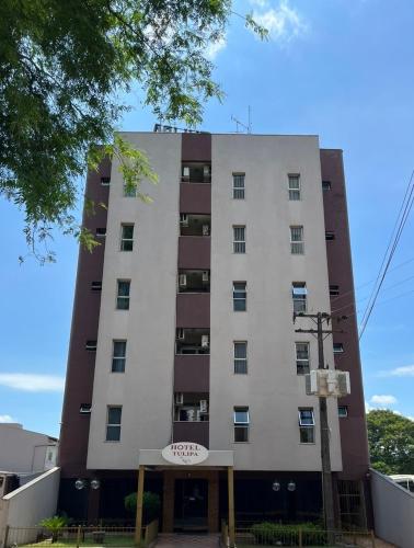 a tall white building with a sign on it at Tulipa Hotel in Foz do Iguaçu