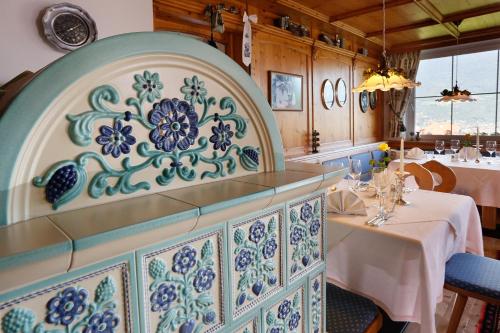 a dining room with a blue and white patterned wall at Landhaus Hotel Kristall in Marlengo