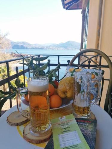 a table with two glasses of beer and a plate of food at Hotel La Rondinella in Cannero Riviera