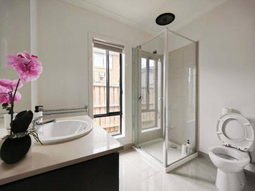a bathroom with a toilet and a sink and a shower at Beautiful 4 Bedrooms Houses in Point Cook