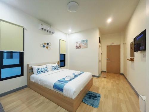 a bedroom with a large bed and a television at DelZiaNa Bara Villa Pakbara Satun พักได้ 6 ท่าน in Satun