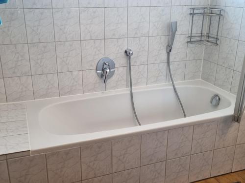 eine weiße Badewanne mit Dusche im Badezimmer in der Unterkunft Haus Aras in Prutz