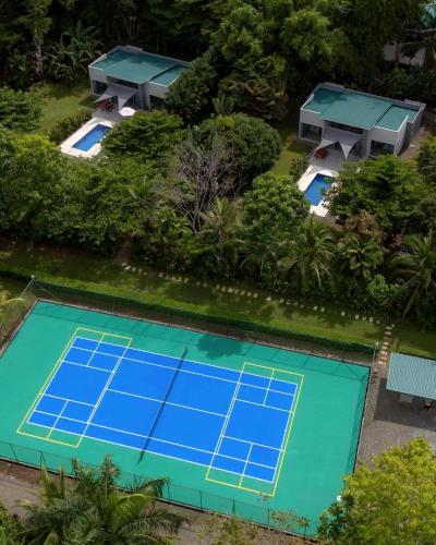 an overhead view of a tennis court with blue tennis courts at Lilan Nature, Modern House N°1, private swimming pool. in Cahuita