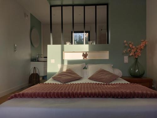 Un dormitorio con una cama grande con dos almohadas. en Île Grande, Location maison saisonnière chez Dom et Cathy C, en Pleumeur-Bodou