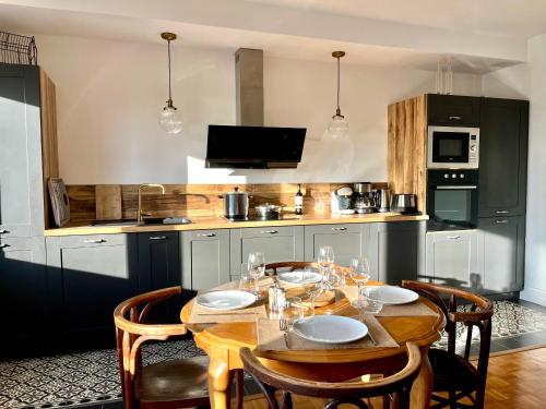 Il dispose d'une cuisine avec une table en bois et des chaises. dans l'établissement LE BARON BUCAILLE appartement face à la mer 300 m de Nausicaa, à Boulogne-sur-Mer