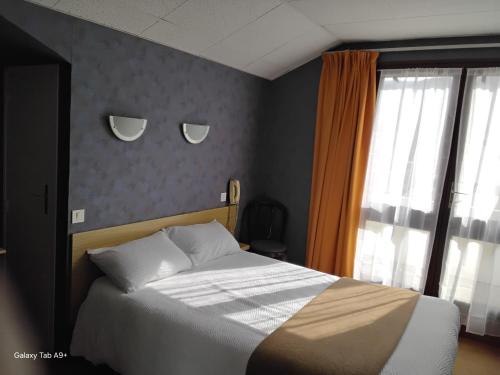 Ένα ή περισσότερα κρεβάτια σε δωμάτιο στο Logis Hôtel L'Elancèze