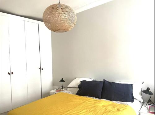 une chambre avec un lit avec une couverture jaune dans l'établissement 3 bedrooms in Montmartre, à Paris