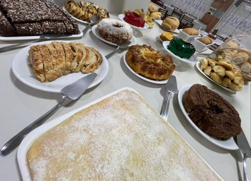 a table full of different types of food on plates at Tulipa Hotel in Foz do Iguaçu