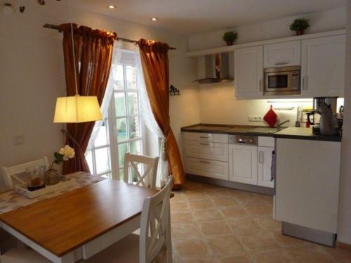 a kitchen and dining room with a table and a table and chairs at Haus-Sonnenschein in Tinnum