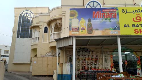a building with a sign in front of a store at SALEM House Hostel Nizwa in Nizwa