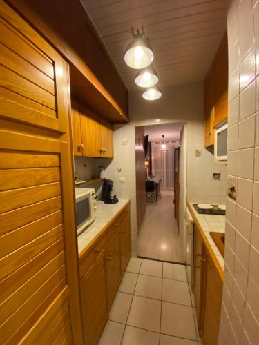 - une cuisine avec des placards en bois et un four micro-ondes dans l'établissement Studio avec vue sur les pistes, à Saint-Étienne-en-Dévoluy