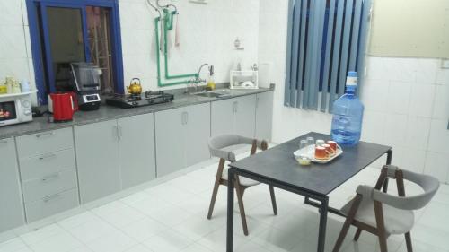 a kitchen with a table with a bottle of water on it at SALEM House Hostel Nizwa in Nizwa