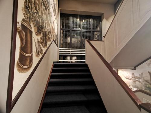 a staircase in a house with art on the walls at Hotel Parkzicht in Valkenburg