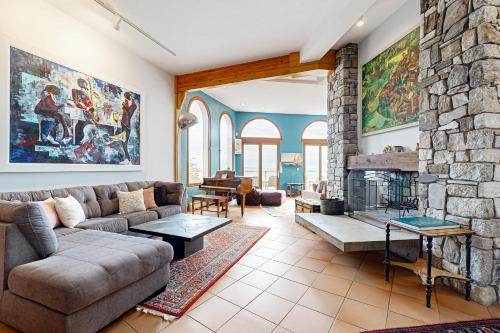 a living room with a couch and a stone fireplace at Oceanfront Gem in East Boothbay